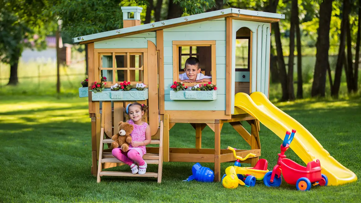 DIY kids playhouse in a sunny backyard, two children playing, colorful slide, wooden structure, outdoor toys, family project