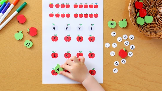 Apple letter match activity for preschoolers with printable worksheet, apple-shaped letter tokens, and a child’s hand matching letters.
