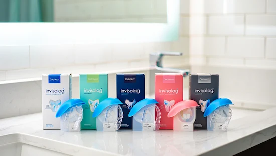 Five different DIY Invisalign kits with colorful branded packaging and clear aligners displayed on a bathroom countertop for product comparison.