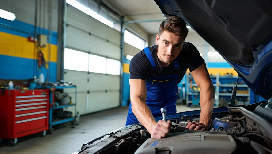 Young man performing car maintenance in a diy auto garage rental near me, surrounded by organized tools and a modern garage workspace.