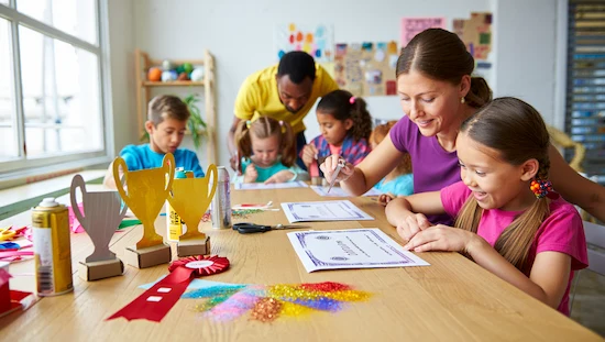Children and adults making creative award diy trophies and certificates together at a craft table, surrounded by colorful art supplies and handmade awards


