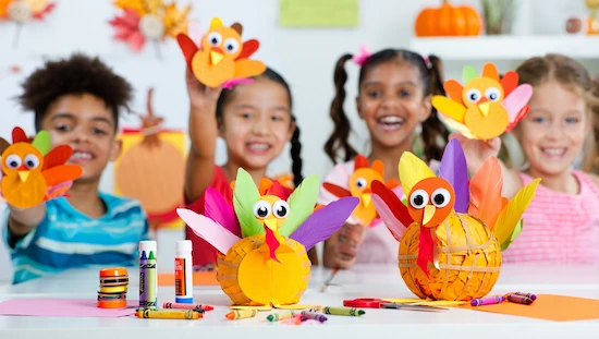Kids showing creative turkey crafts made with printable templates in a colorful Thanksgiving classroom.