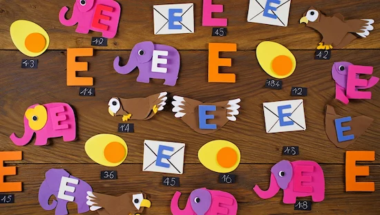 Colorful Letter E preschool crafts including elephants, eggs, eagles, and envelopes, displayed neatly on a wooden background.