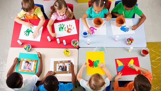 Children making craft for grandparents day preschool, including handprint art, flower pots, photo frames, and colorful paper crafts.