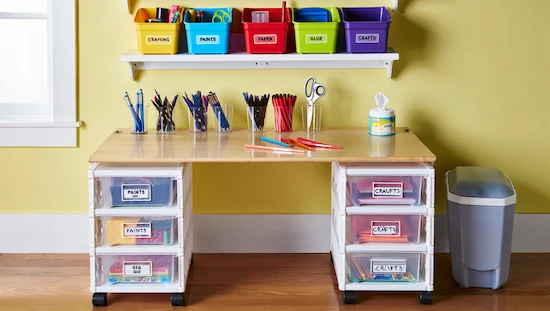 Organized diy kid craft desk with labeled bins, drawer organizers, and cleaning supplies for easy maintenance.