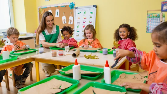 Teacher and preschoolers enjoying a well-organized earth day craft preschool session with eco-friendly supplies.

