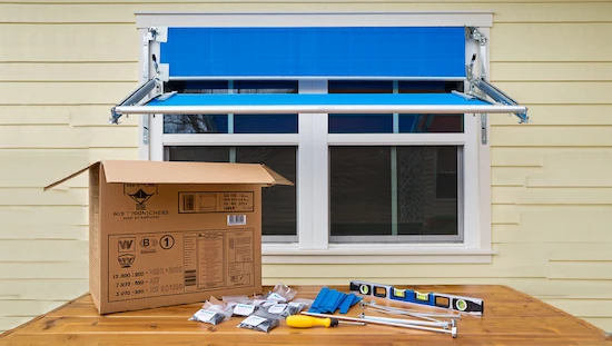 DIY window awning kits with tools, mounting brackets, and a blue awning above a window; perfect window awning DIY sets at home.