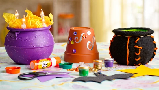 Easy DIY cauldron crafts for kids featuring colorful decorated cauldrons, paint, glue, and craft supplies for creative fun projects.