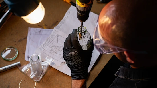 DIY bong kit assembly step-by-step, showing gloved hands drilling glass bottle with safety goggles and plans for safe homemade bong.