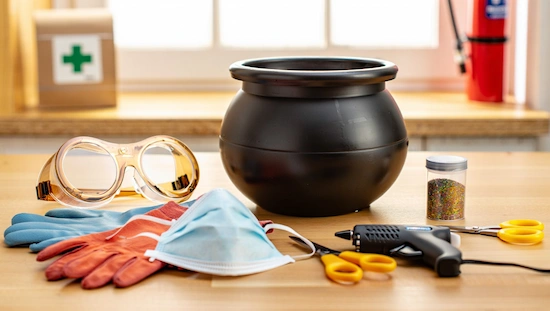 Easy DIY cauldron crafting safety tips, featuring gloves, goggles, face mask, hot glue gun, and supplies for a safe creative project.