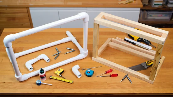 DIY awning frame comparison showing both PVC pipe frame and wood frame with tools on a wooden workbench, DIY awning frame options